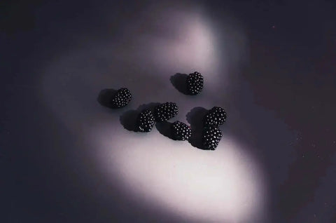 Blackberries on dark background, representing autumn anthocyanins in skincare