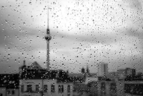 Berlin skyline with TV tower seen through raindrops, symbolizing weather and skincare