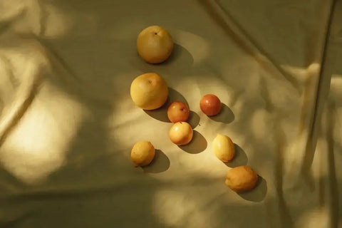 Various fruits on golden fabric, symbolizing bioflavonoids for skin health