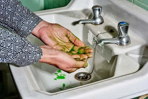 Hands under green-tinted water symbolizing greenwashing in natural cosmetics